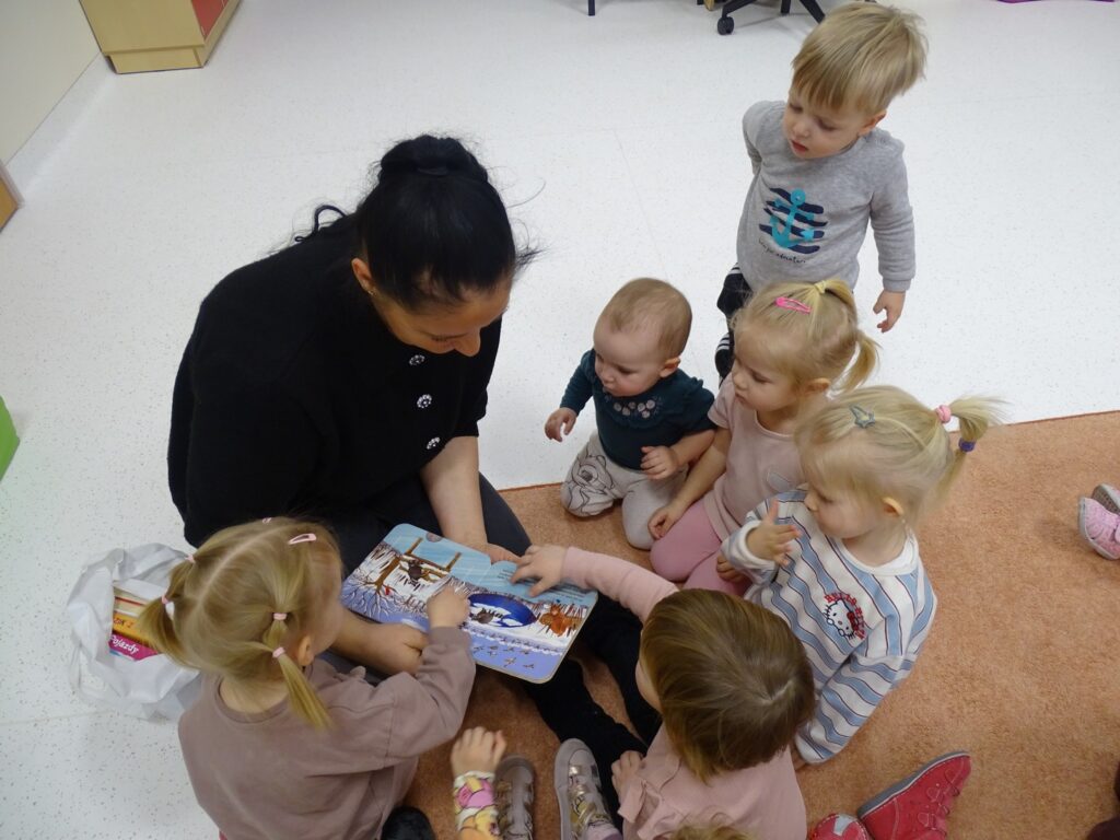 Pani pokazuje dzieciom obrazki w książce