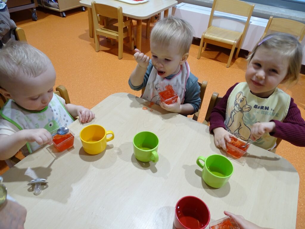 Dzieci jedzą przy stolikach