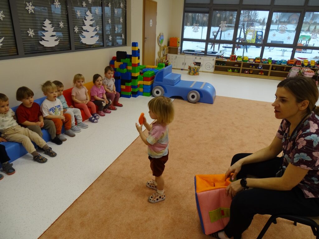 Dziewczynka pokazuje dzieciom wylosowane koło