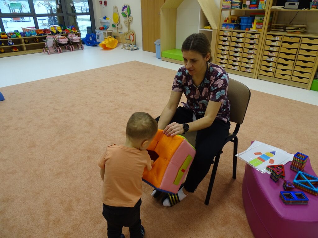 Chłopczyk losuje figurę geometryczną