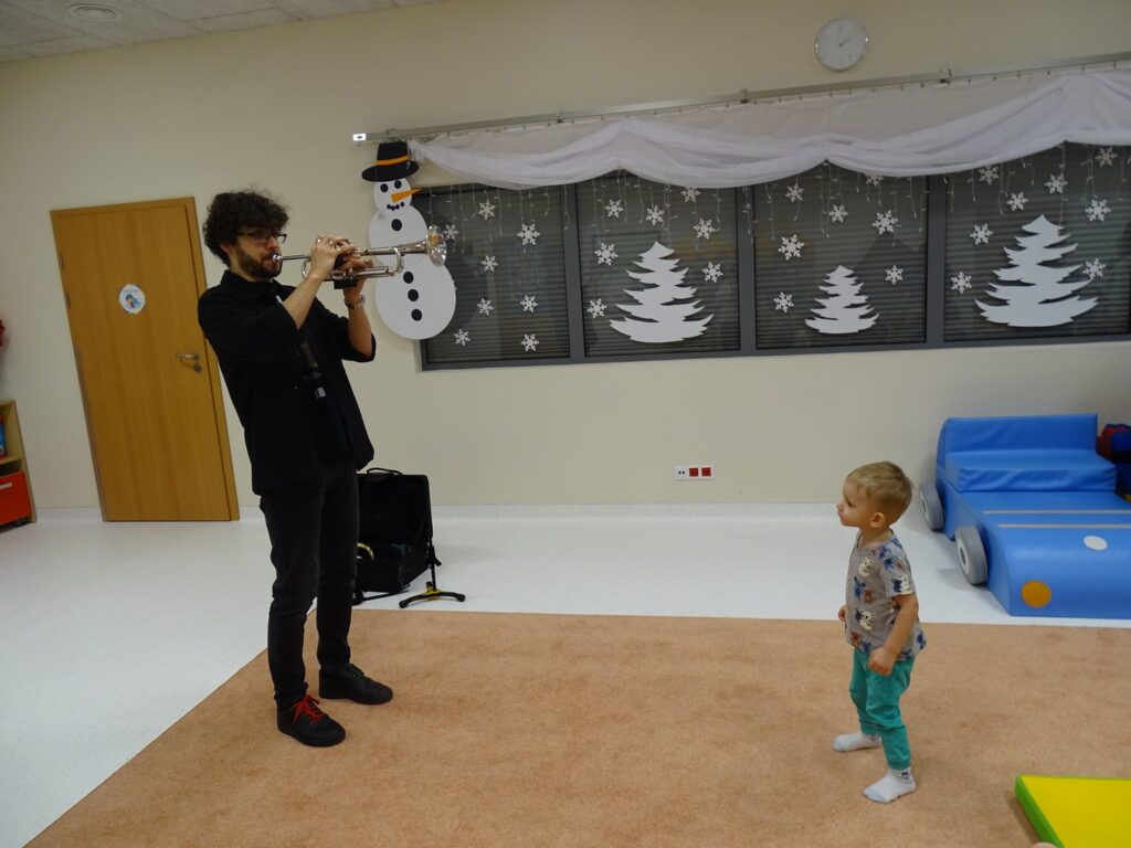 Chłopczyk słucha jak pan gra na trąbce