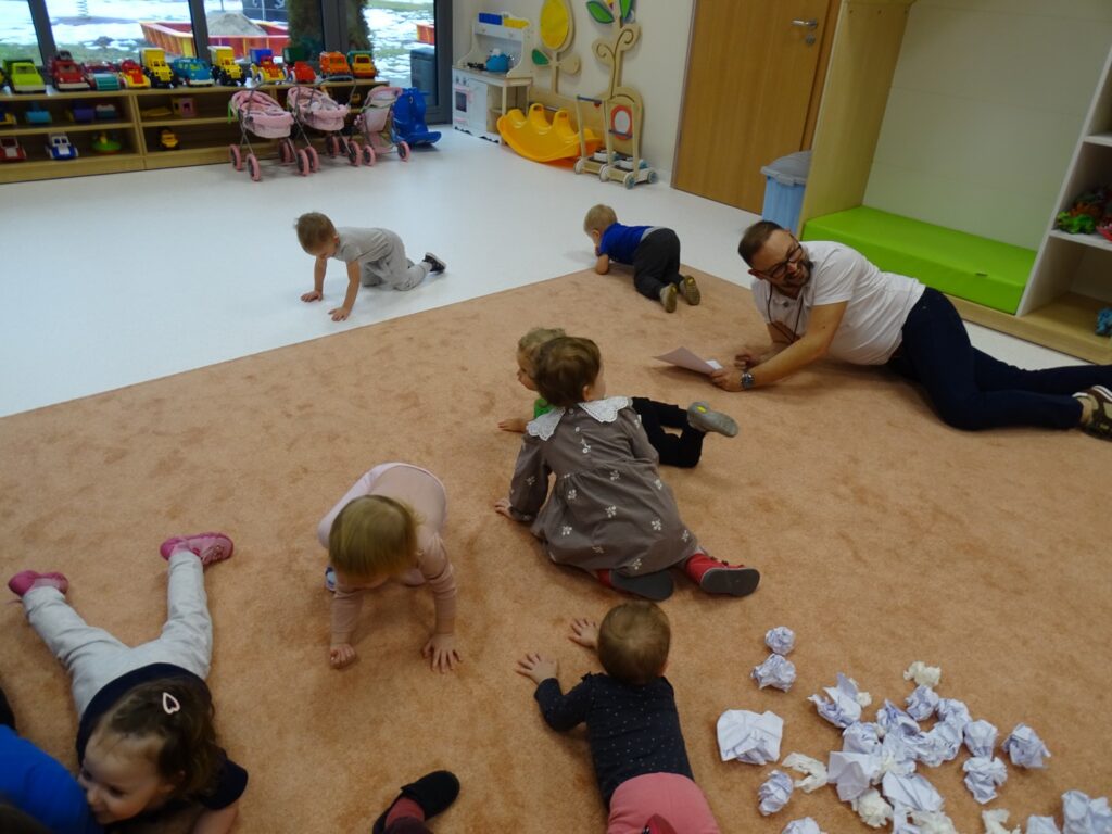 Dzieci czołgają się po dywanie udając węża