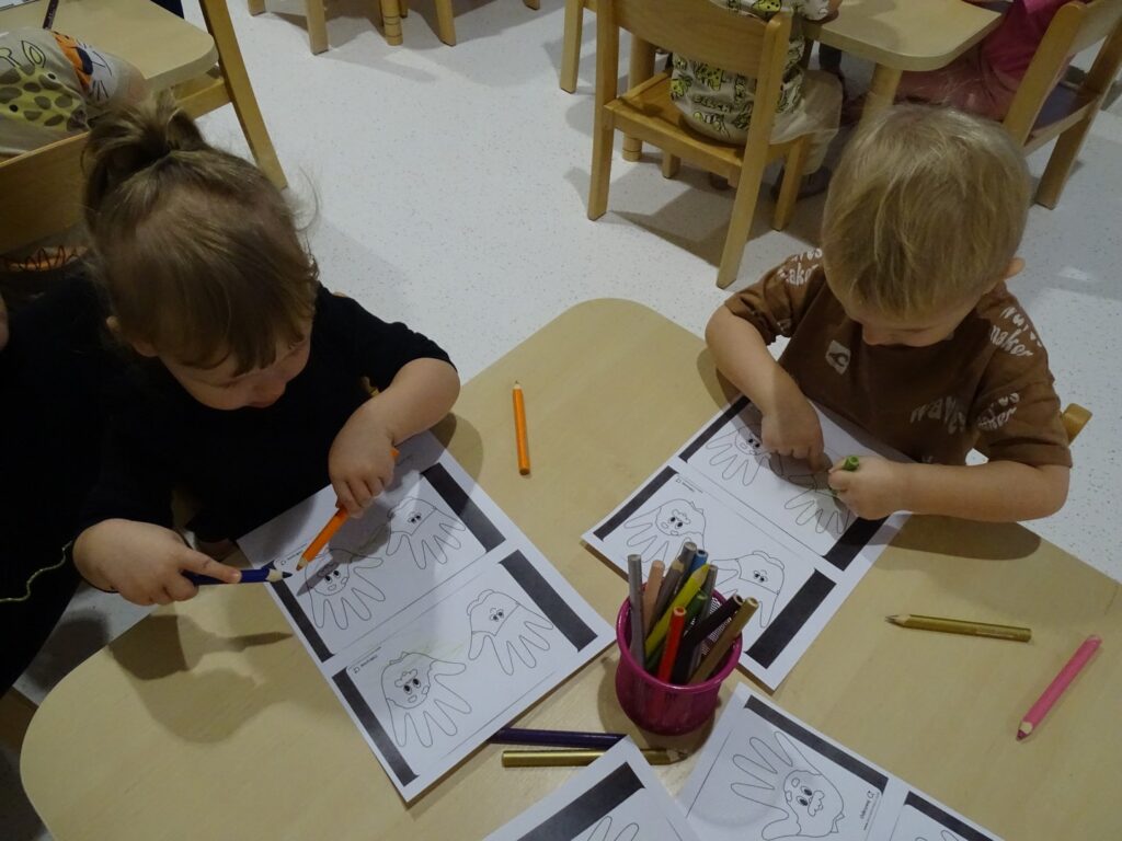 Dzieci malują obrazki kredkami