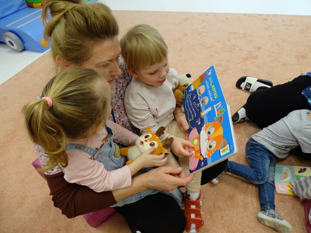 Opiekunka czyta dziewczynkom książkę