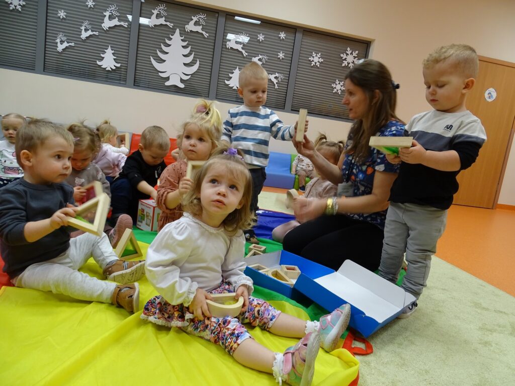 Dzieci bawią się drewnianymi figurami