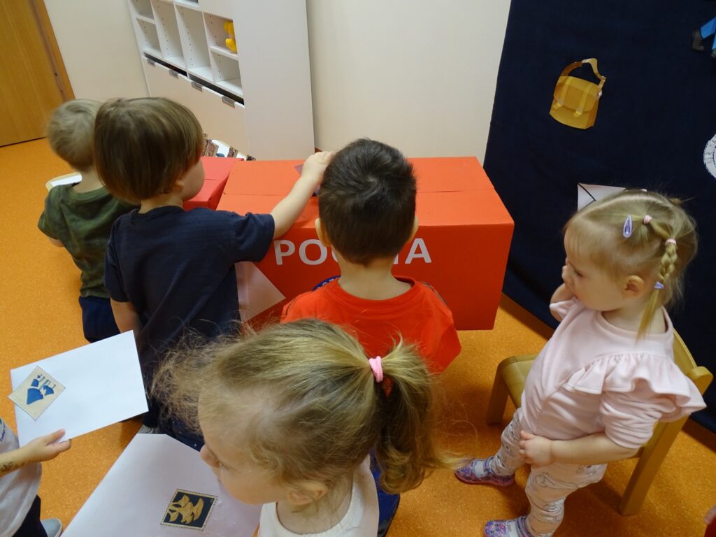 Dzieci czekają aby wrzucić list do skrzynki