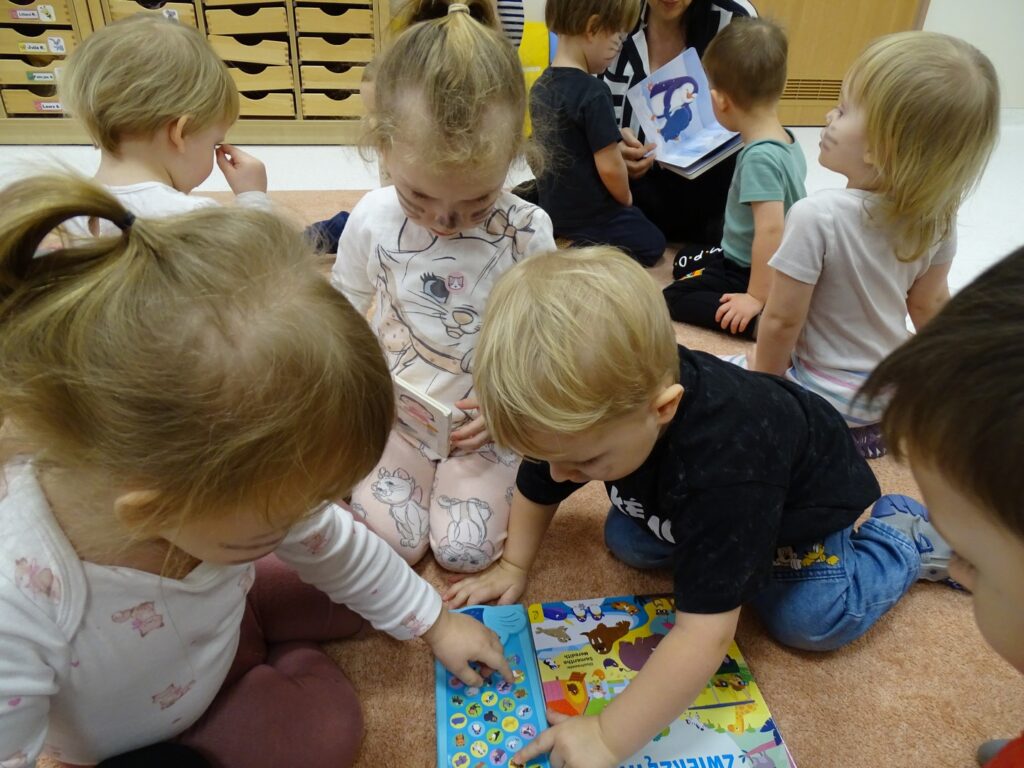 Dzieci naciskają guziczki w książce