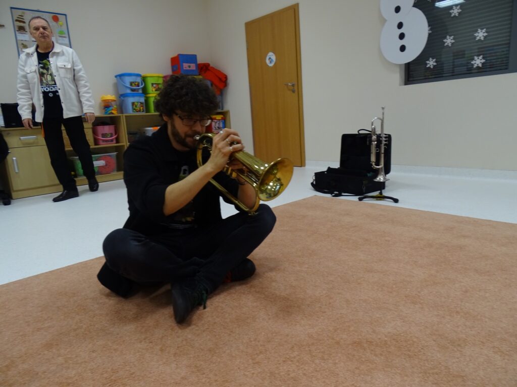 Pan siedząc gra na trąbce