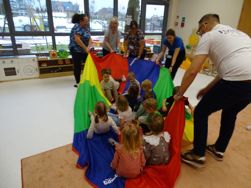 Dzieci jadą na wielkich saniach z chusty animacyjnej