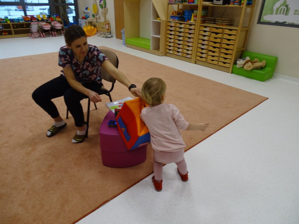 Dziewczynka losuje figurę geometryczną