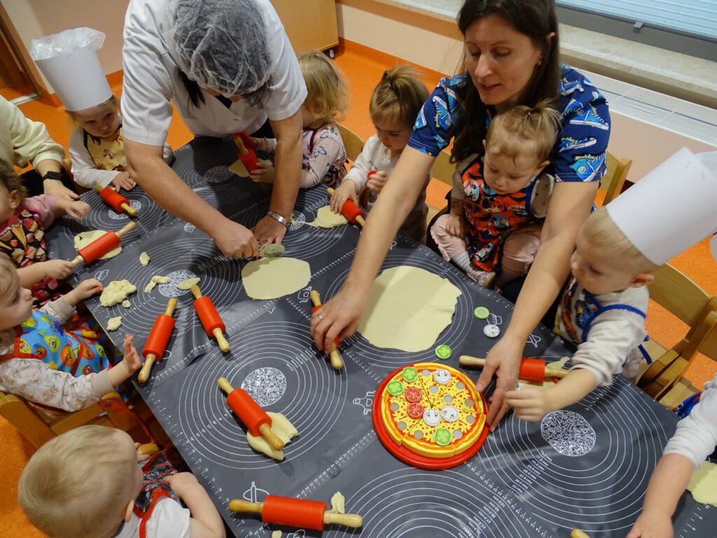 Opiekunowie pomagają wałkować ciasto