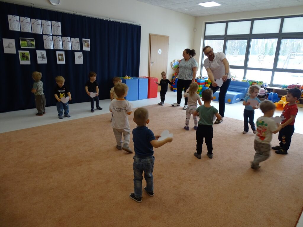 Dzieci tańczą trzymając papierowe serduszka
