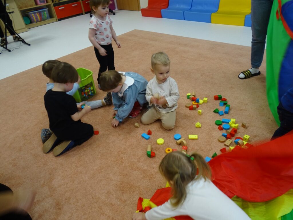 Dzieci wrzucają klocki - pokarm ptaszków do pudełka