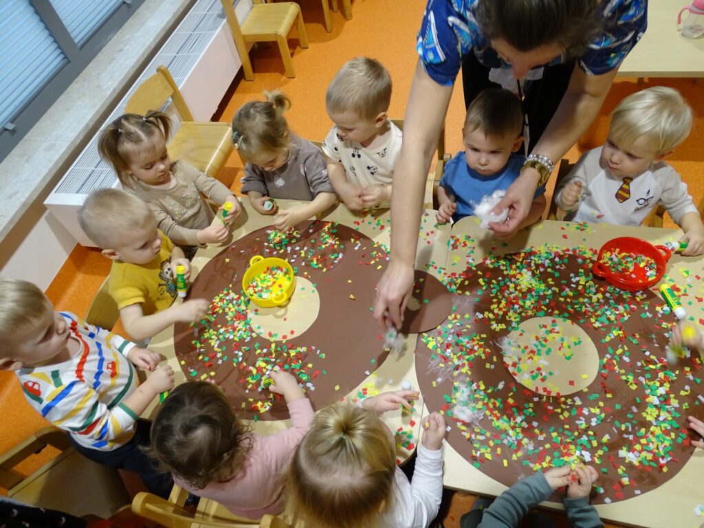 Dzieci wspólnie pracują nad pracą plastyczną
