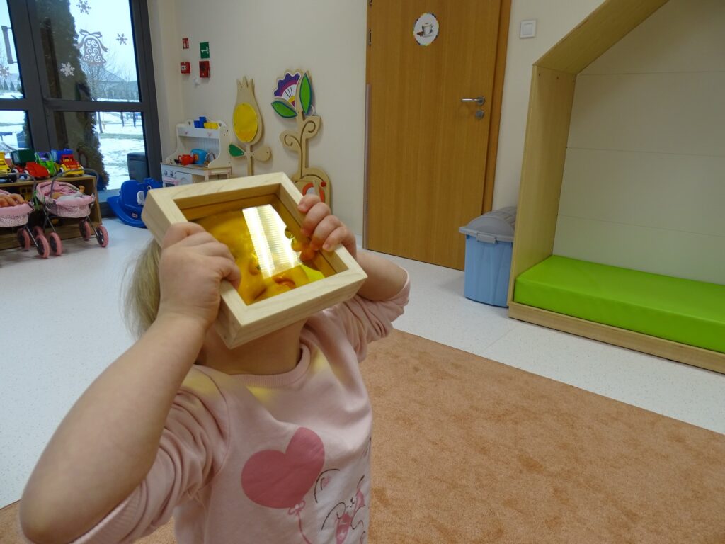 Dziewczynka wygląda przez żółty kwadracik