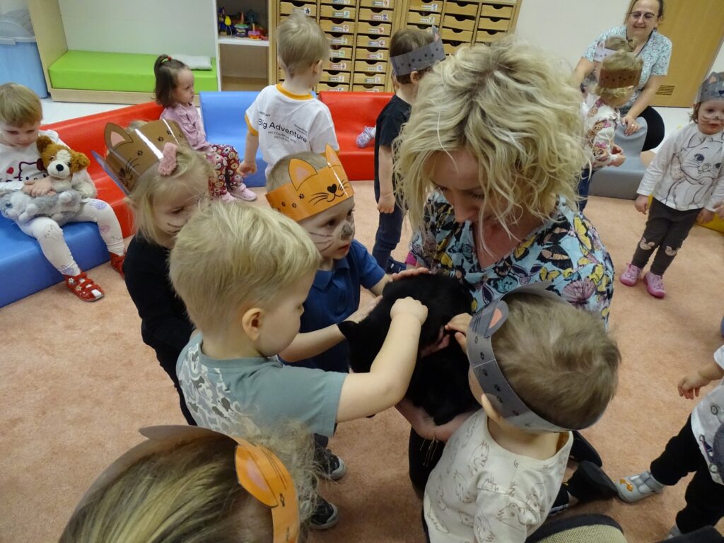 Dzieci głaszczą kotka
