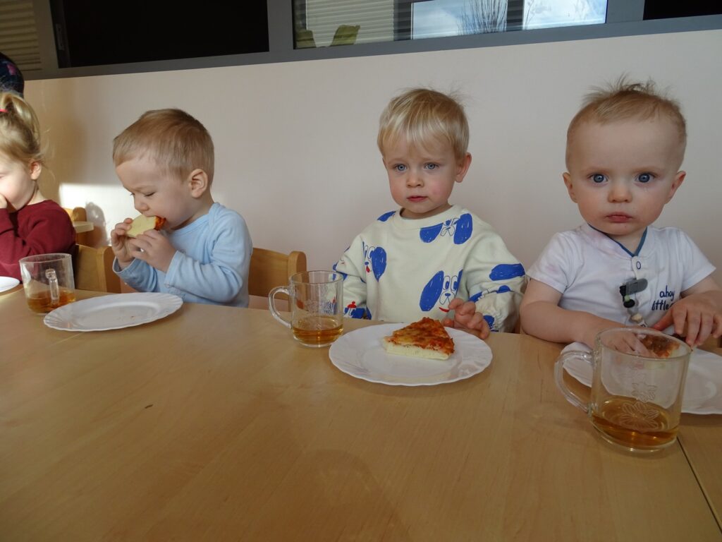 Dzieci jedzą pizzę