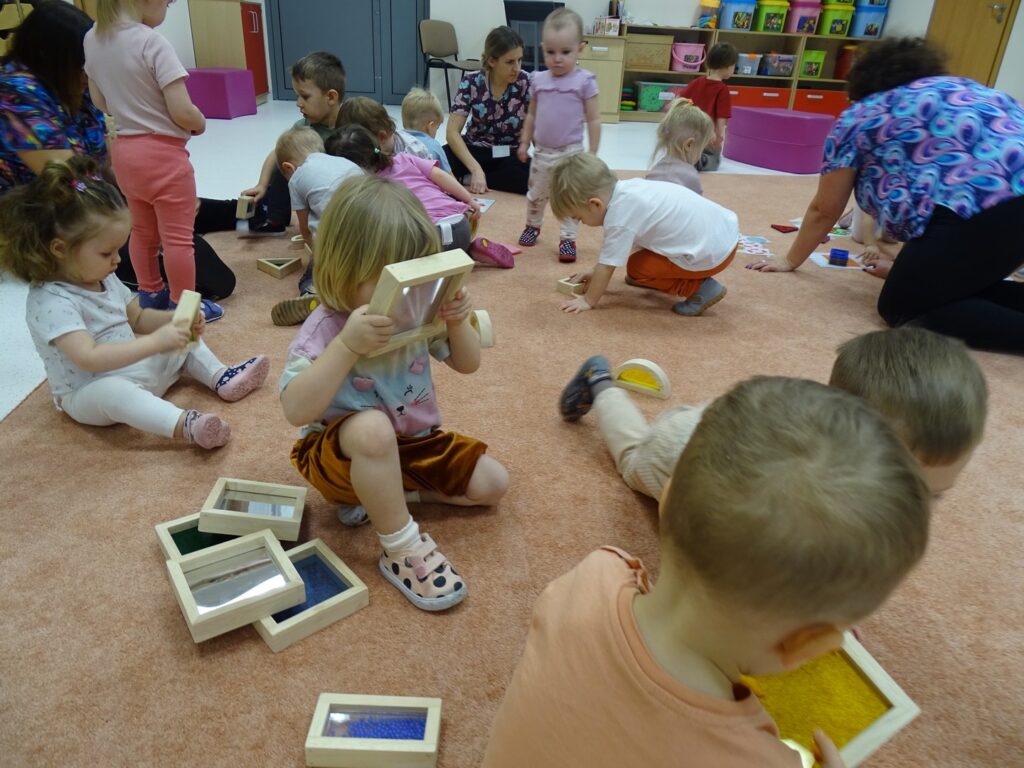 Dzieci oglądają kolorowe figury geometryczne