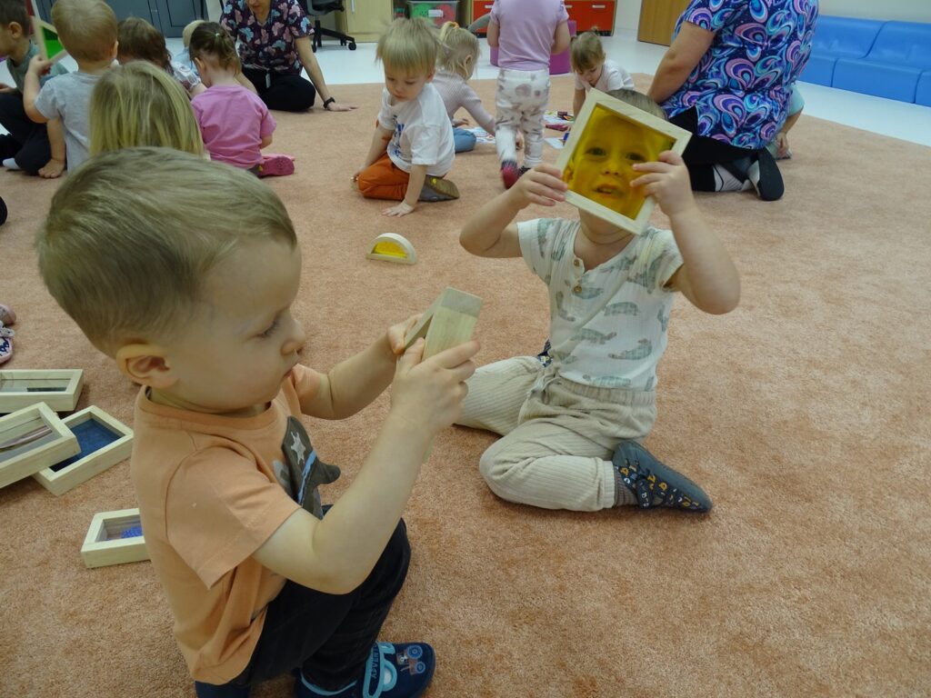 Chłopczyk patrzy przez kolorowy kwadracik