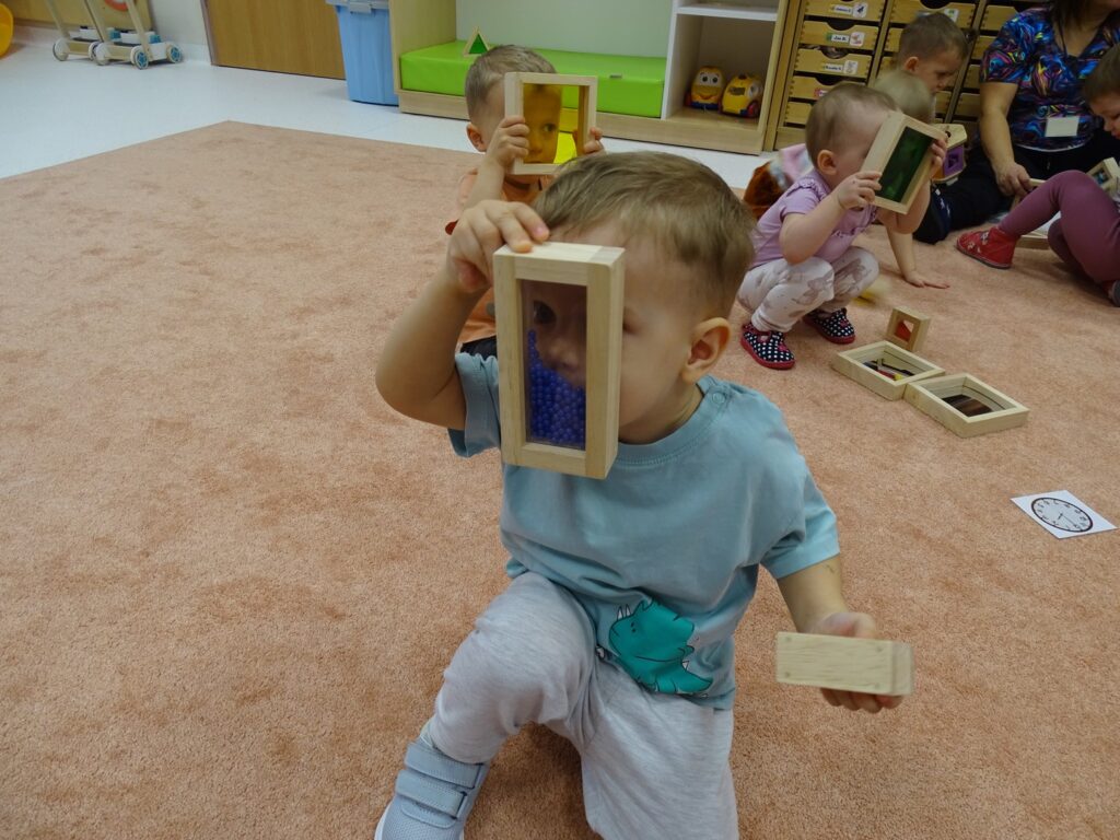 Chłopczyk patrzy przez niebieski prostokąt