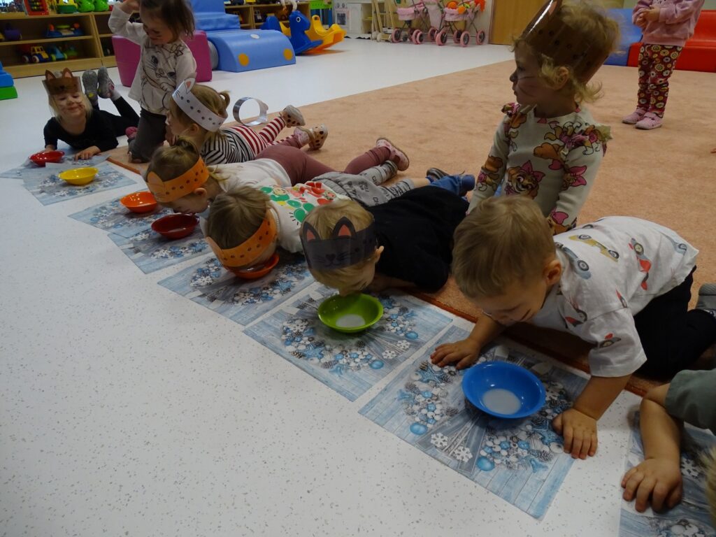 Dzieci piją mleczko z miseczek