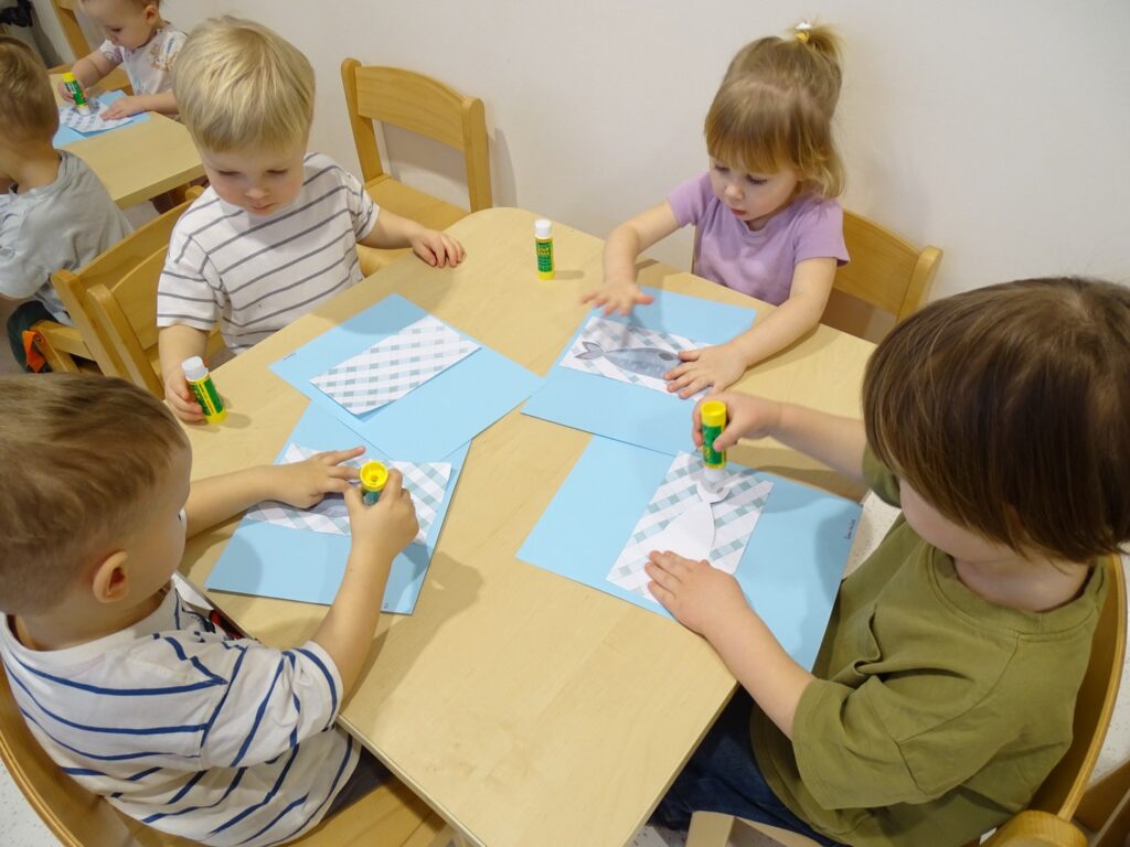 Dzieci smarują obrazek klejem