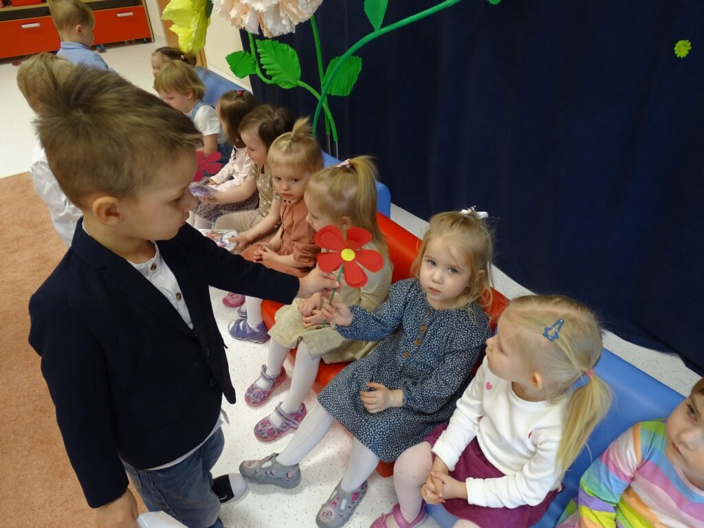 Chłopczyk wręcza kwiaty koleżance