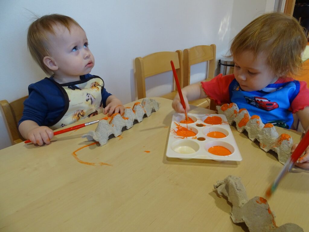 Dziewczynka z chłopcem maluje farbą