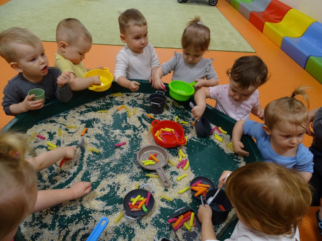Dzieci bawią się przy stoliku sensorycznym