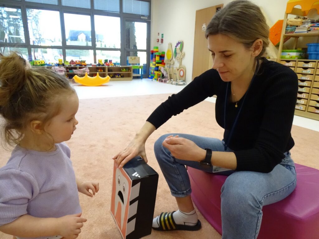 Dziewczynka wrzuca obrazek do pudełka