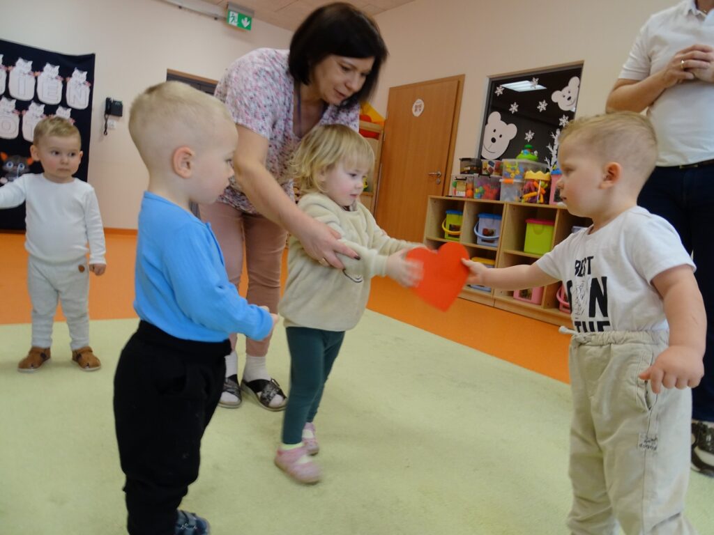 Opiekunka pomaga dziewczynce wręczyć serce