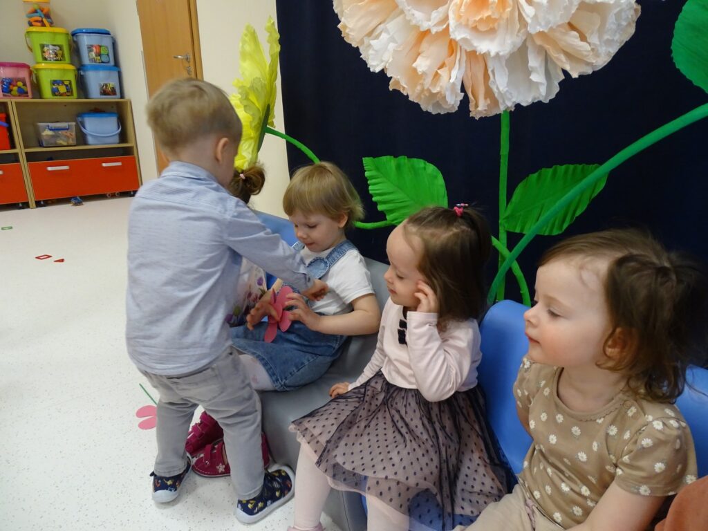 Chłopczyk wręcz koleżance kwiatka