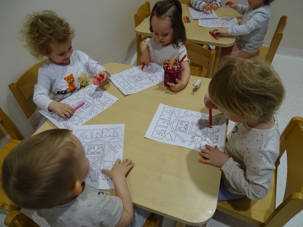 Dzieci malują obrazek kredkami