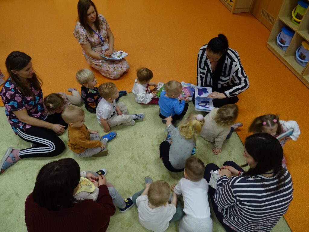 Dzieci siedzą na dywanie