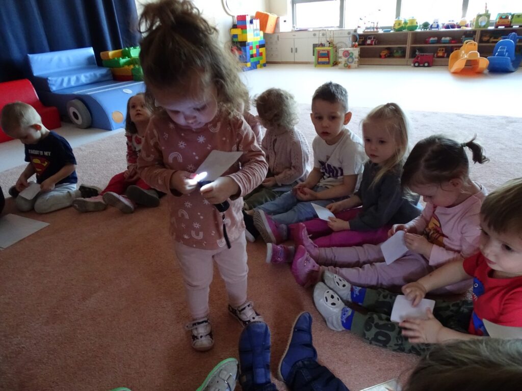 Dziewczynka podświetla obrazek latarką