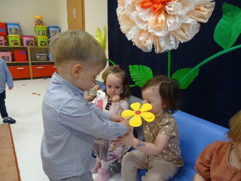 Koleżanka przyjmuje od kolegi kwiatuszka