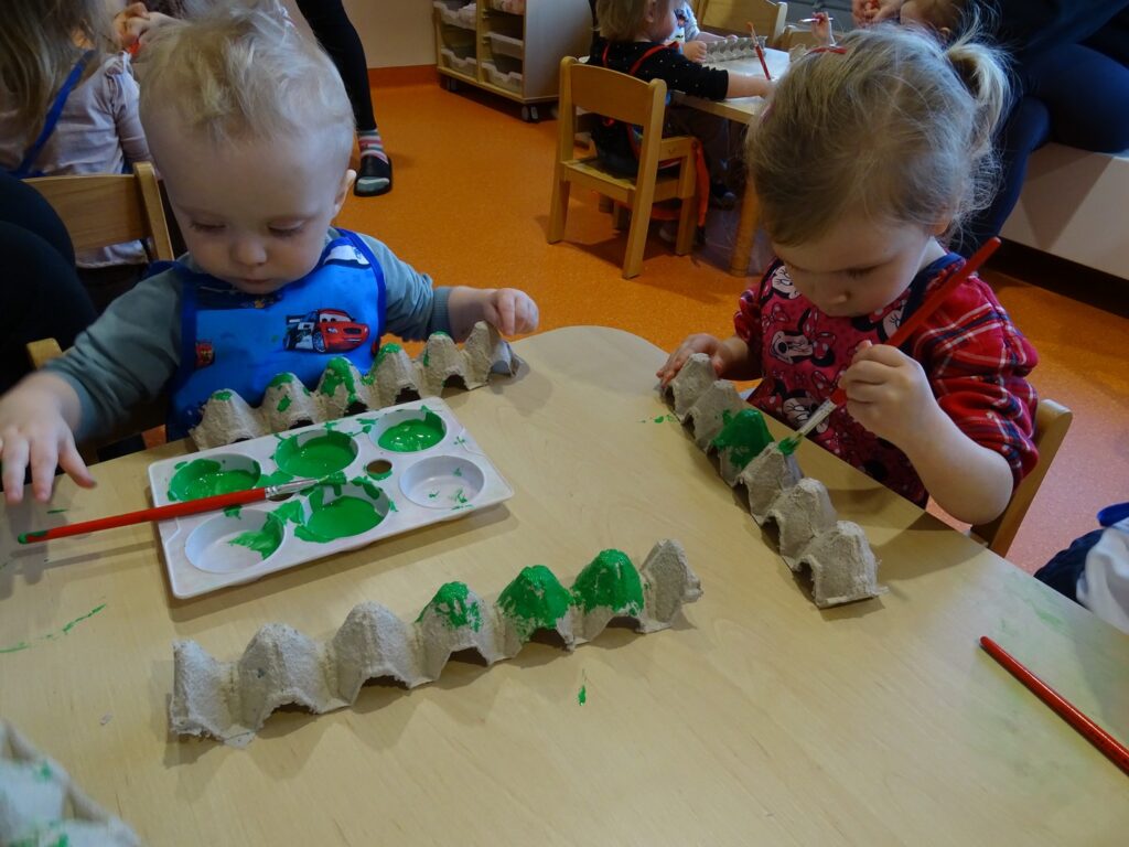 Dzieci malują zieloną farbą