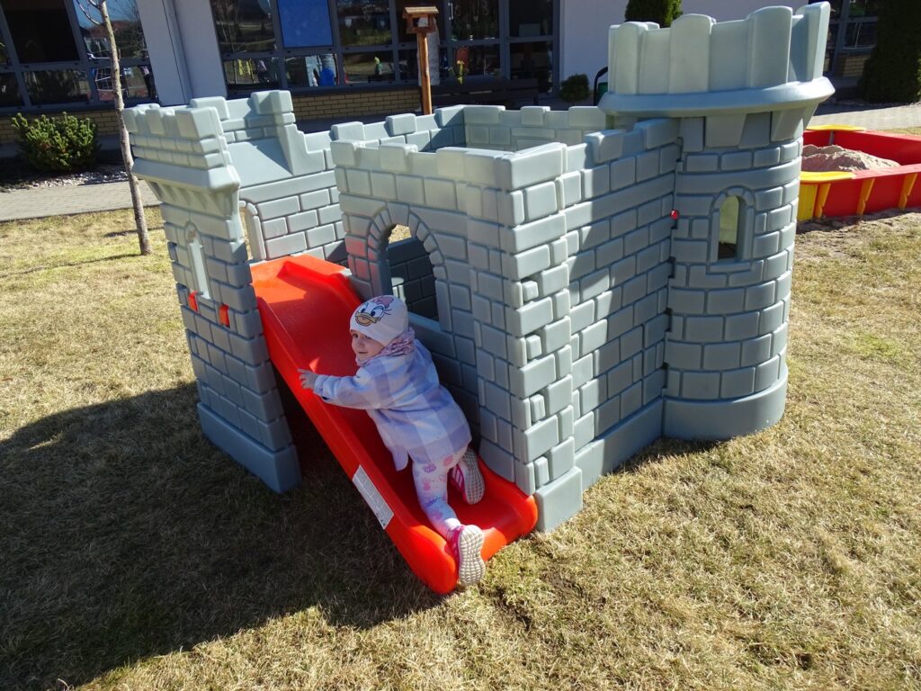 Dziewczynka wspina się na zjeżdżalnię