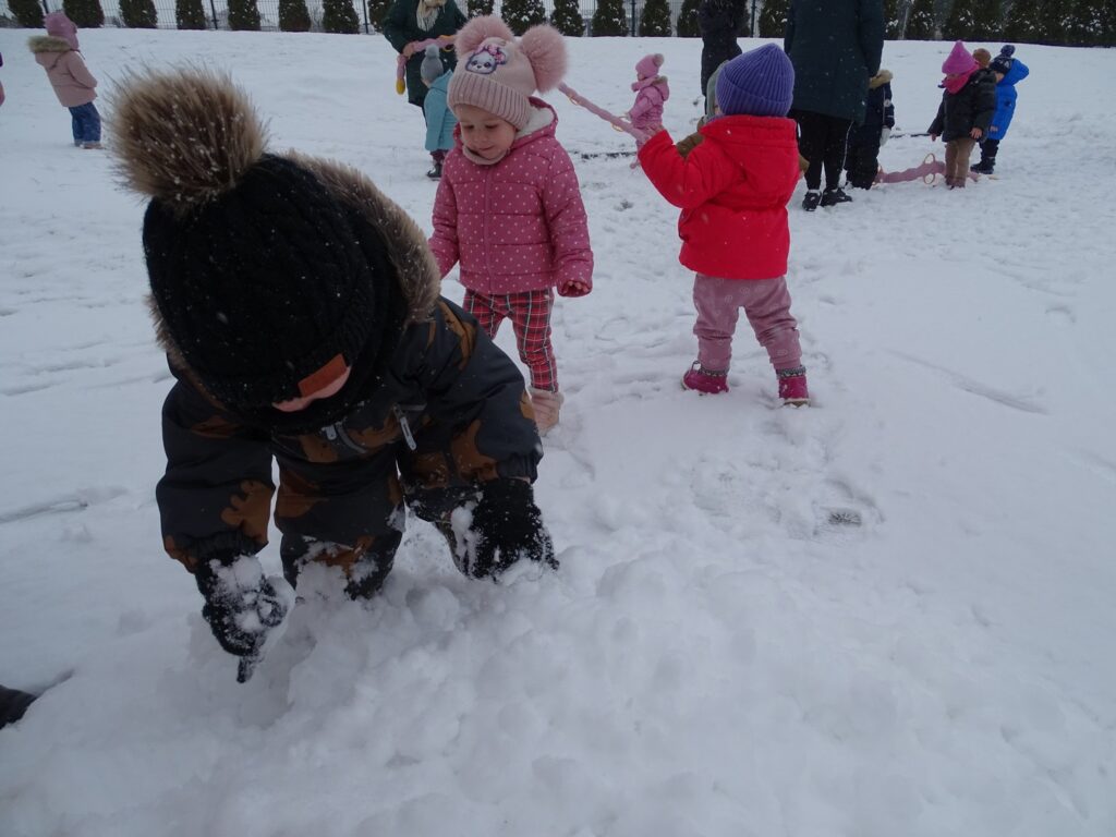 Chłopiec bawi się śniegiem