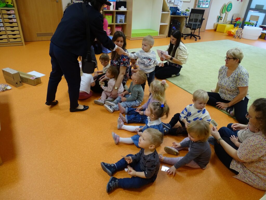 Listonosz rozdaje dzieciom znaczki