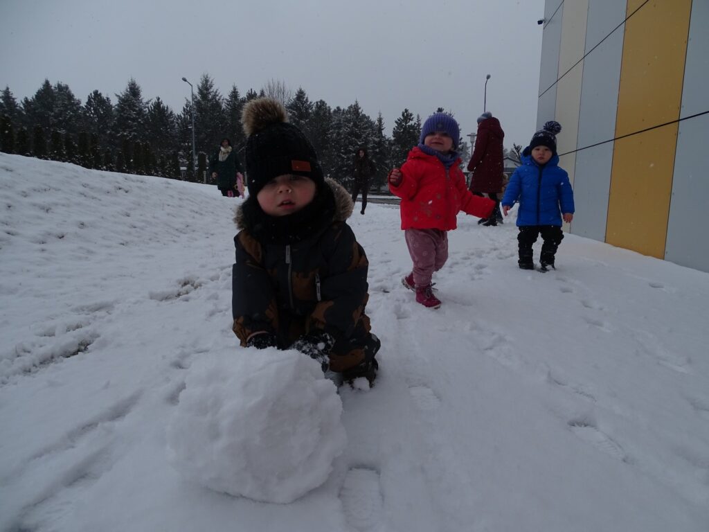 Chłopczyk toczy kulę