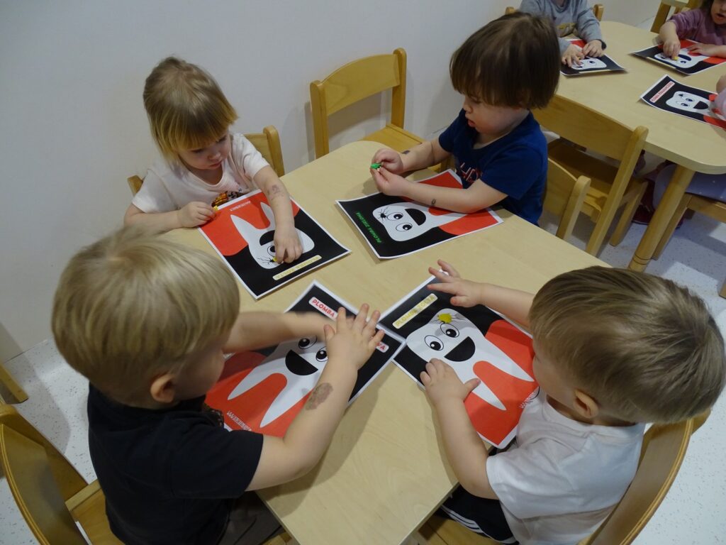 Dzieci wypełniają ząbka plasteliną