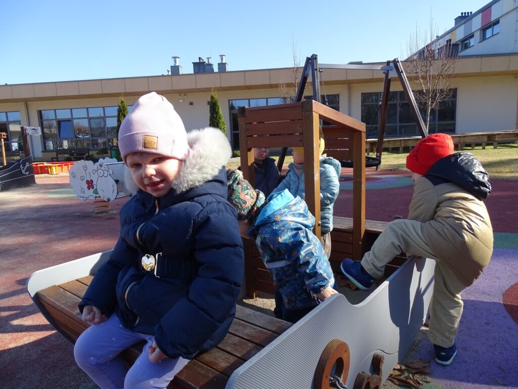 Dziewczynka siedzi na ławeczce