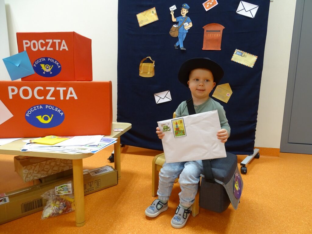 Chłopczyk w przebraniu listonosza z listem