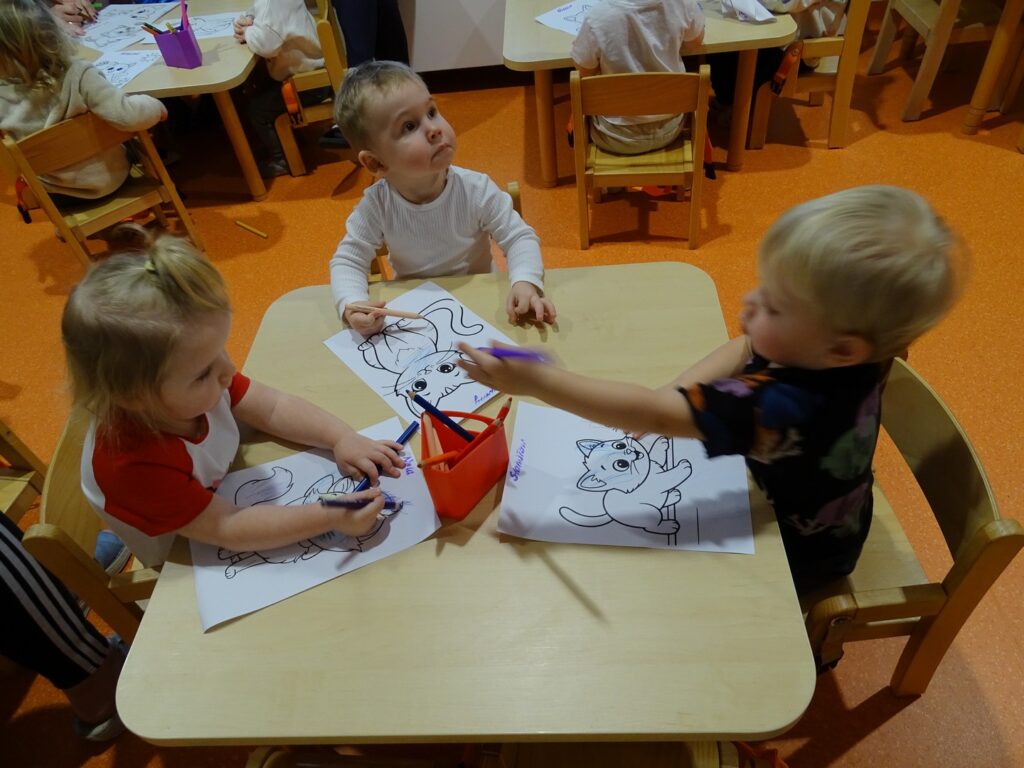 Dzieci wspólnie kolorują kredkami