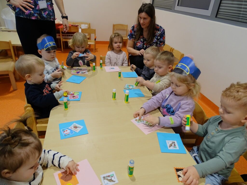 Dzieci przy stolikach wykonują pracę plastyczną