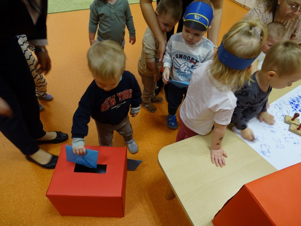 Chłopczyk wrzuca list do skrzynki