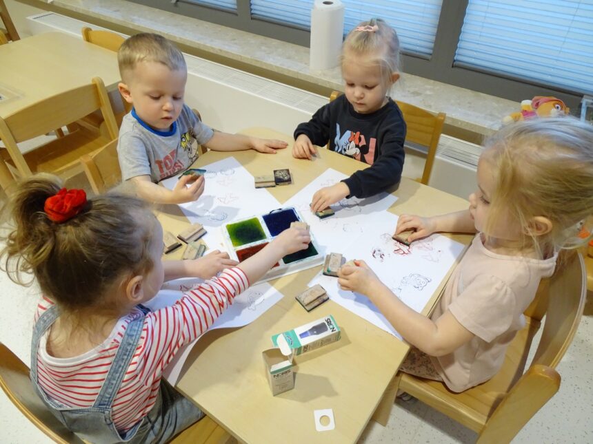 Dzieci odbijają kolorowe pieczątki