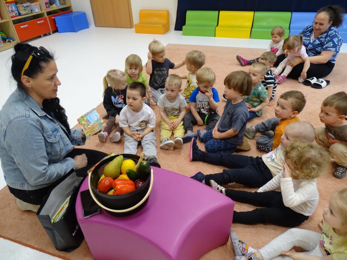 Pani czyta dzieciom książkę o warzywach
