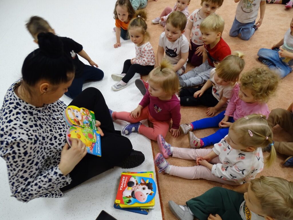 Pani pokazuje dzieciom obrazki w książce